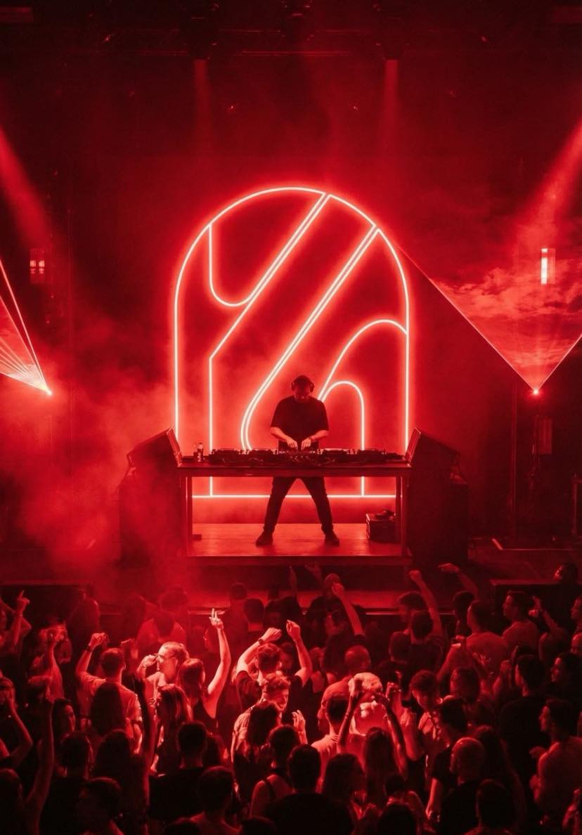 L'enseigne KOWA en néon rouge derrière le DJ, au-dessus de la piste