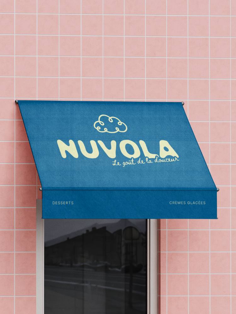 L'auvent bleu de la boutique NUVOLA, logo au nuage, sur un mur de carrelage rose