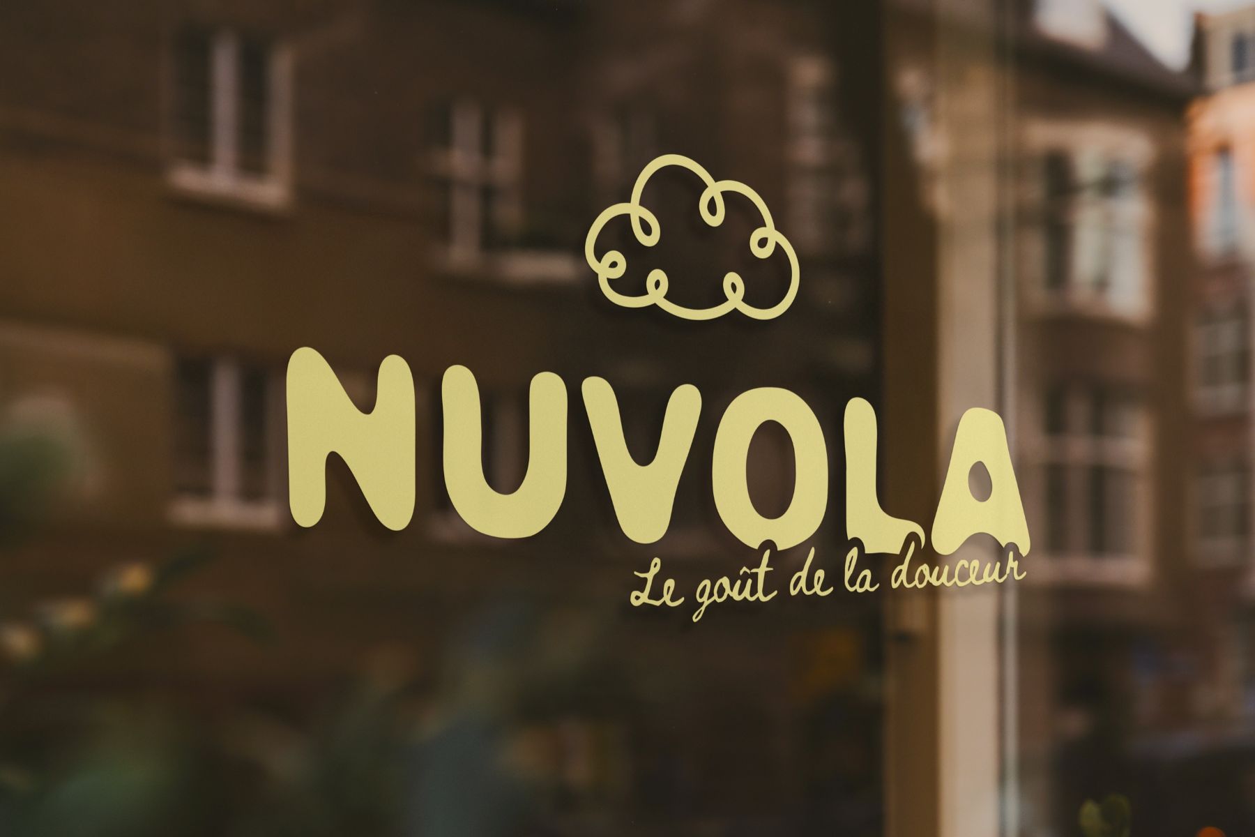 Le logotype NUVOLA doré, peint sur la vitrine de la boutique