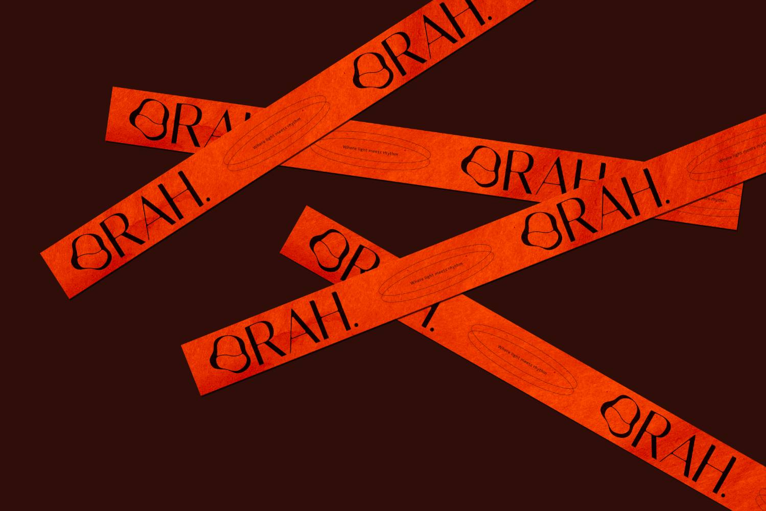 Des rubans adhésifs ORAH. orange vif, croisés sur un fond brun sombre